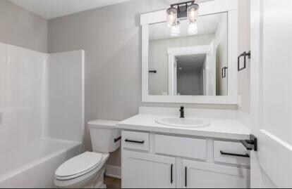 full bathroom with vanity, toilet, and  shower combination