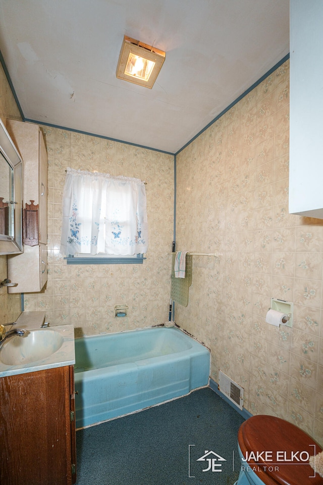 bathroom with vanity, a bathtub, and toilet