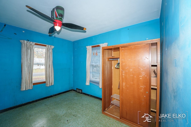 unfurnished bedroom featuring ceiling fan and a closet