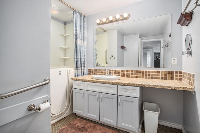 bathroom featuring vanity and tasteful backsplash