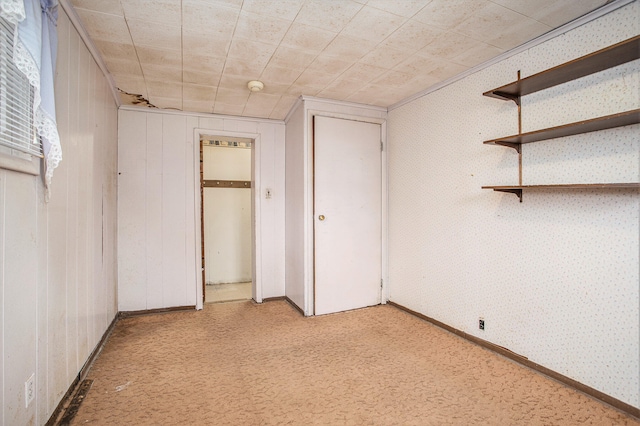 unfurnished bedroom featuring wood walls and a closet