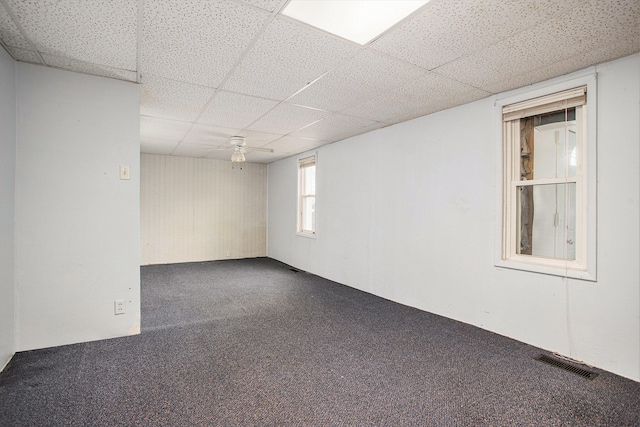 unfurnished room with ceiling fan and a drop ceiling