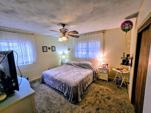 carpeted bedroom featuring ceiling fan and a textured ceiling