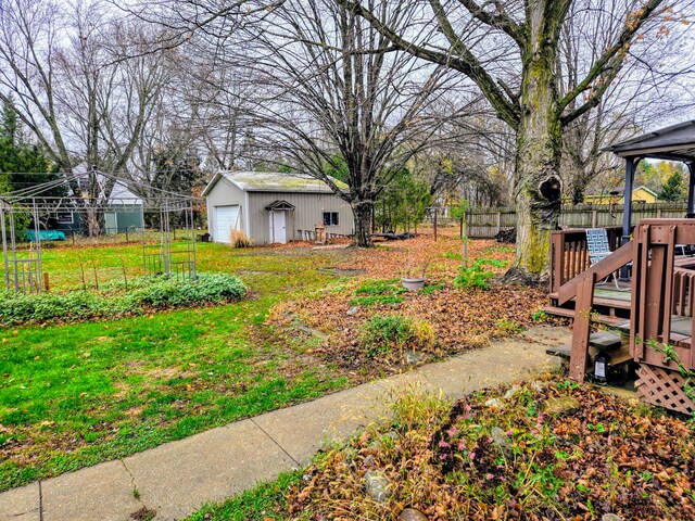 view of yard with a deck, a garage, and an outdoor structure