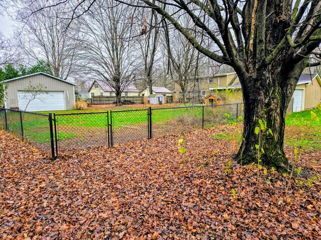 view of yard featuring a garage and an outbuilding