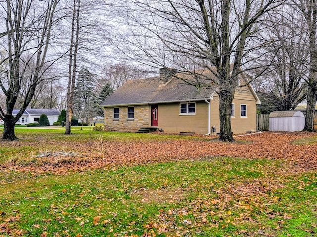 view of front of house with a front yard and a storage unit