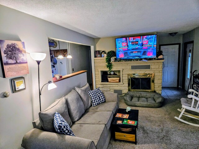 living room with a stone fireplace, carpet floors, and a textured ceiling