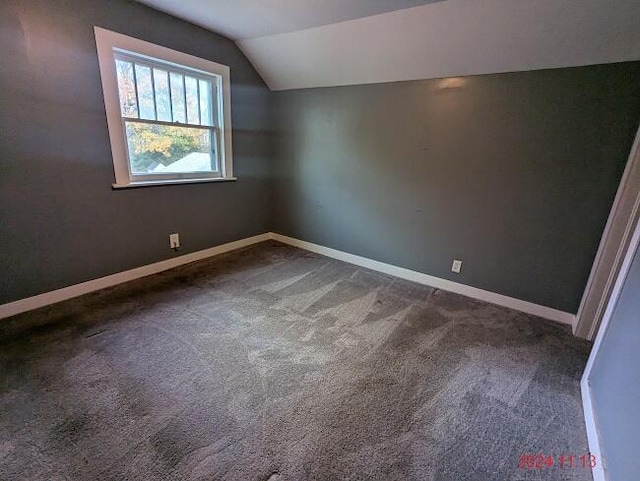 bonus room featuring dark colored carpet and lofted ceiling