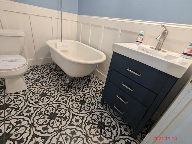 bathroom with toilet, vanity, and tile patterned floors