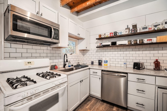 kitchen with dark wood-type flooring, sink, beam ceiling, white cabinetry, and stainless steel appliances