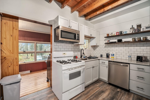 kitchen with beam ceiling, white cabinetry, sink, dark hardwood / wood-style floors, and appliances with stainless steel finishes