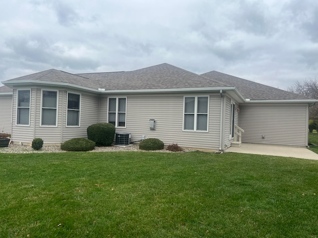 rear view of property with a patio area, a yard, and central air condition unit