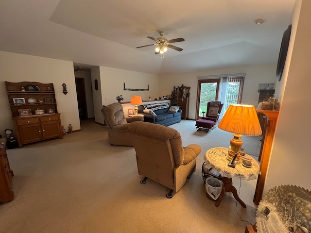 carpeted living room with ceiling fan and a raised ceiling