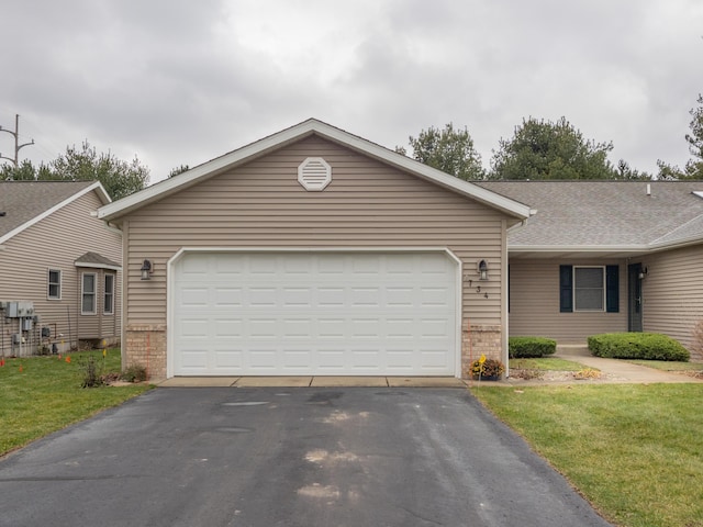 ranch-style house featuring a front yard and a garage