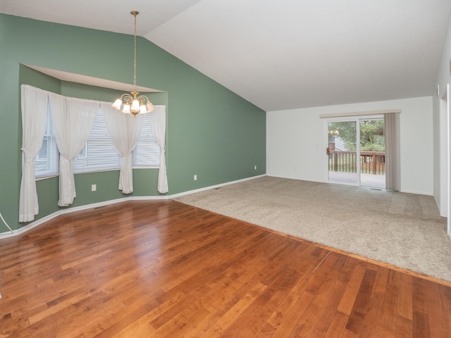 carpeted empty room featuring lofted ceiling and an inviting chandelier