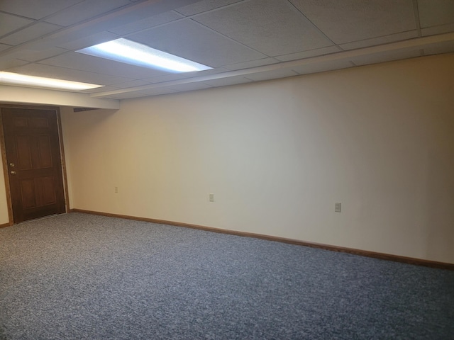 empty room featuring carpet and a drop ceiling