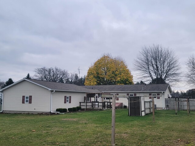 back of house featuring a deck and a lawn