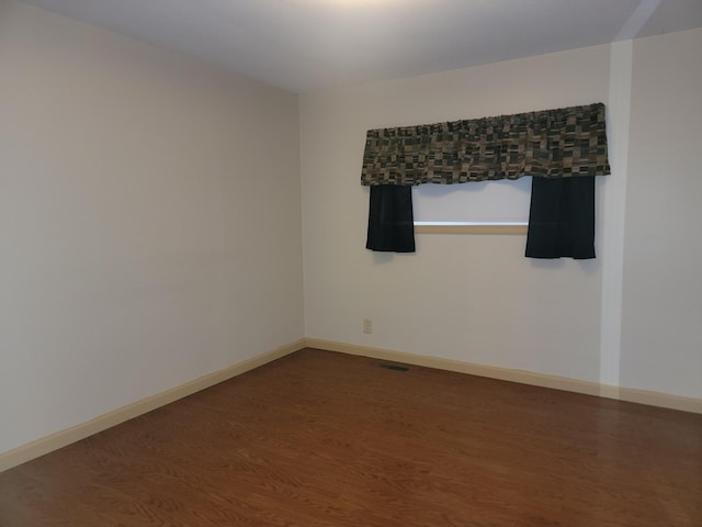 spare room with wood-type flooring