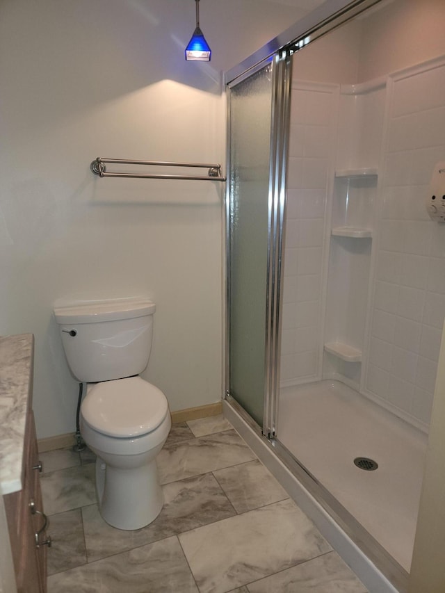 bathroom with vanity, toilet, and a shower with shower door