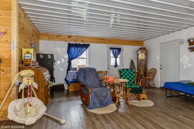 sitting room featuring dark hardwood / wood-style floors and wooden walls