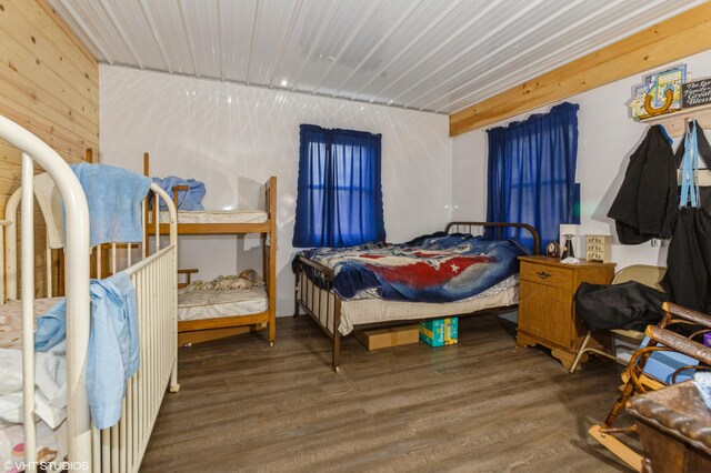 bedroom featuring wood-type flooring and wooden walls