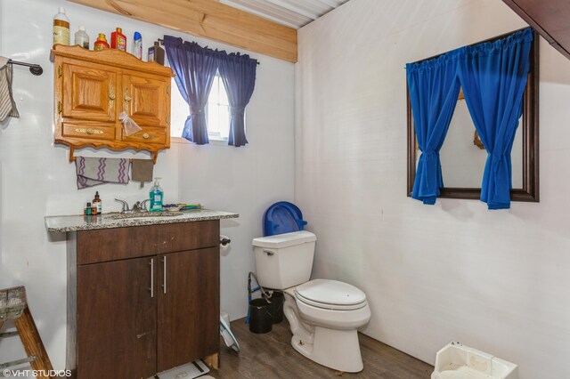 bathroom with hardwood / wood-style floors, vanity, and toilet