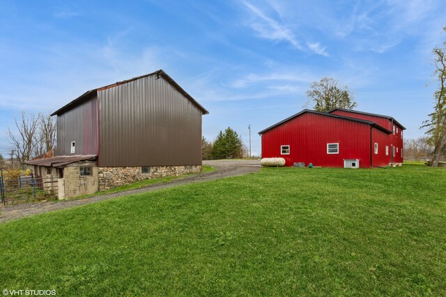 view of side of home featuring an outdoor structure and a lawn