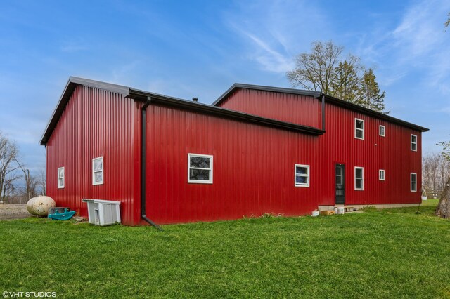 view of property exterior with a lawn and an outbuilding