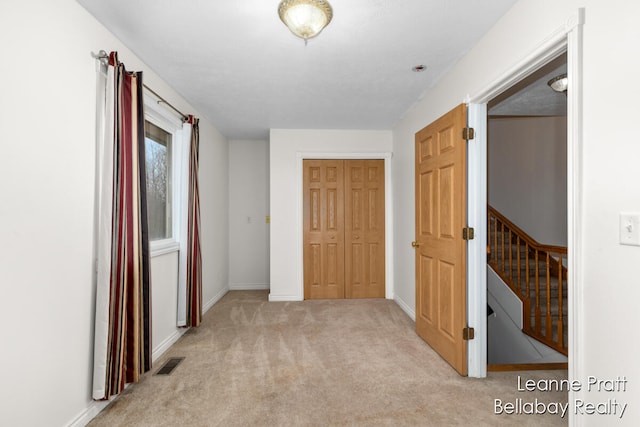 hall featuring light colored carpet