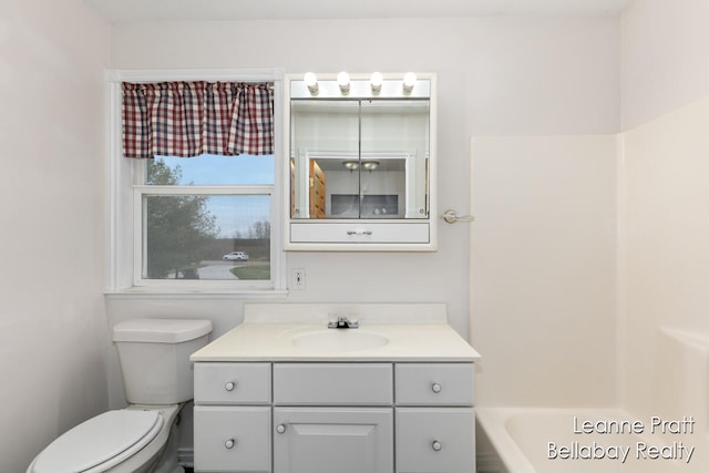 bathroom featuring a bathing tub, vanity, and toilet