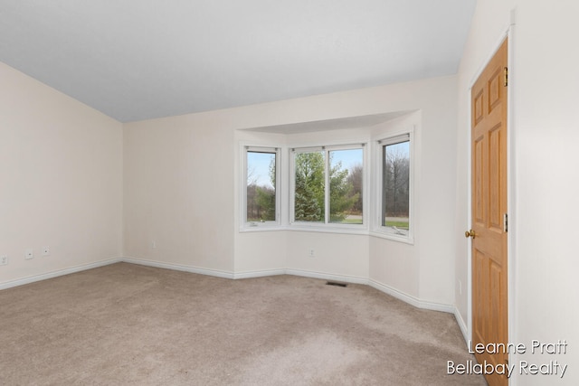 unfurnished room featuring light carpet