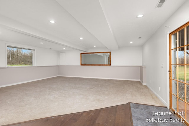 carpeted spare room featuring beamed ceiling