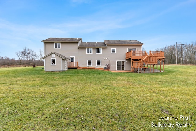 back of property with a yard, a storage unit, and a deck