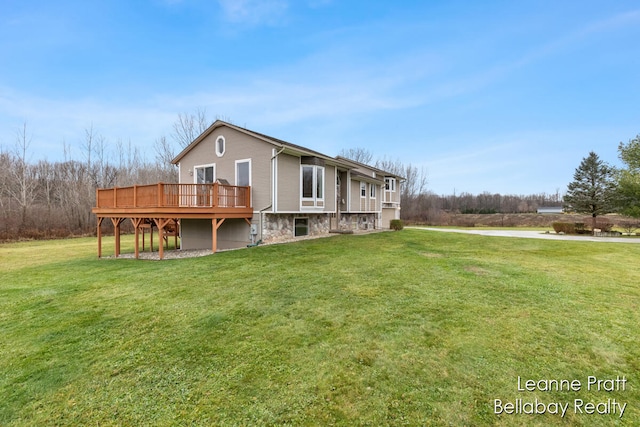 rear view of house featuring a yard and a wooden deck