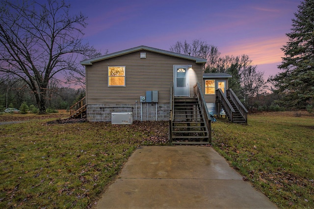 view of front of home featuring a yard and central air condition unit