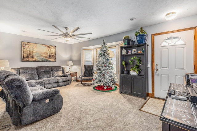 living room featuring light carpet, a textured ceiling, and ceiling fan