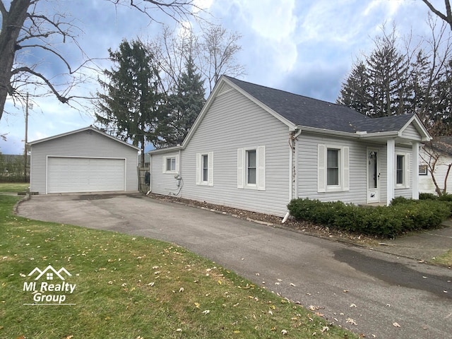 view of side of property featuring a garage, an outdoor structure, and a lawn