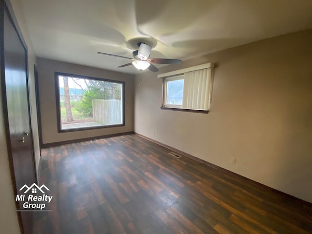 empty room featuring ceiling fan and dark wood-type flooring