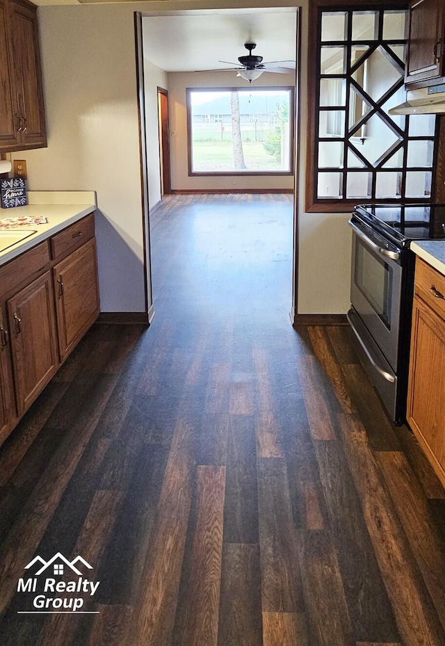 kitchen with ceiling fan, stainless steel electric range oven, dark wood-type flooring, and exhaust hood