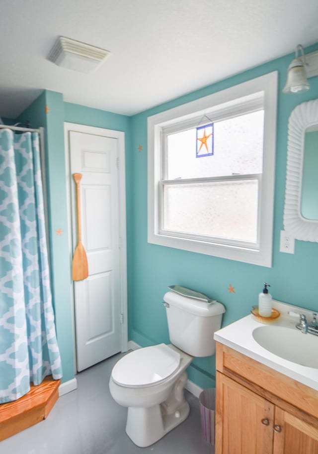 bathroom featuring vanity, curtained shower, and toilet