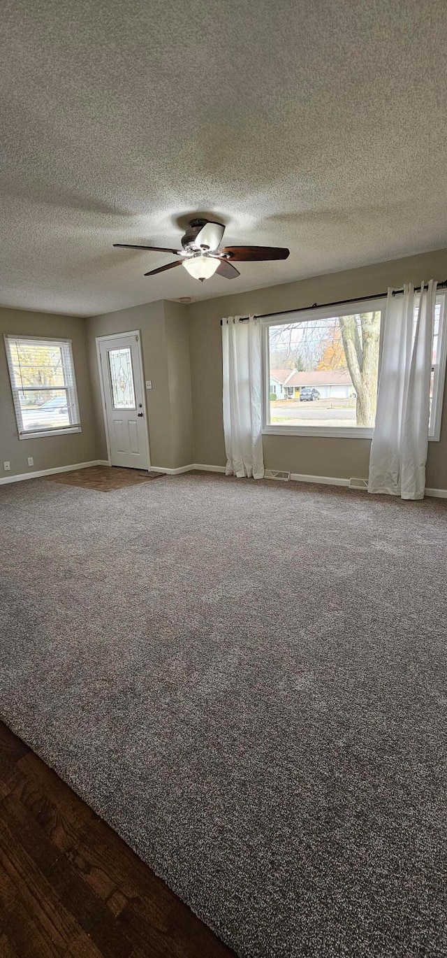 empty room featuring hardwood / wood-style flooring, ceiling fan, and a textured ceiling