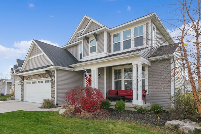 view of front facade featuring a porch, a garage, and a front lawn