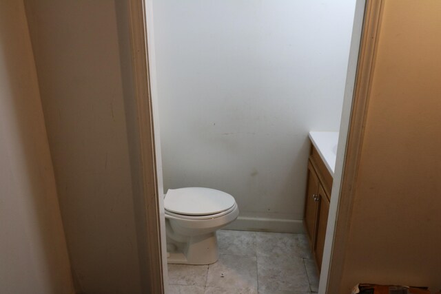 bathroom with tile patterned flooring, vanity, and toilet