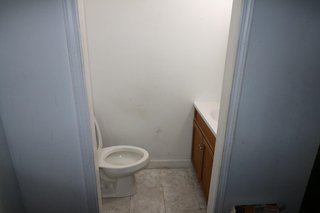 bathroom with toilet, vanity, and tile patterned floors