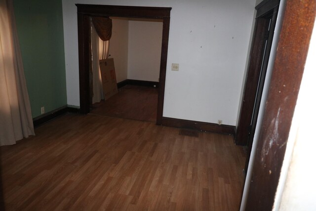 empty room with dark hardwood / wood-style flooring