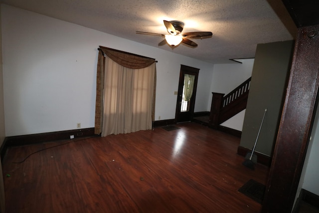 foyer entrance featuring a textured ceiling, ceiling fan, and dark hardwood / wood-style floors