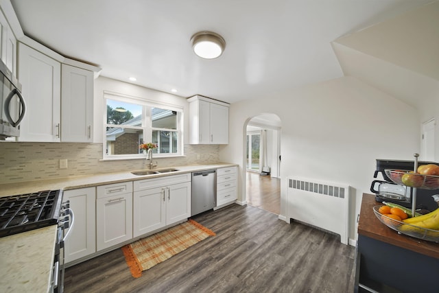 kitchen with sink, white cabinetry, stainless steel appliances, and radiator