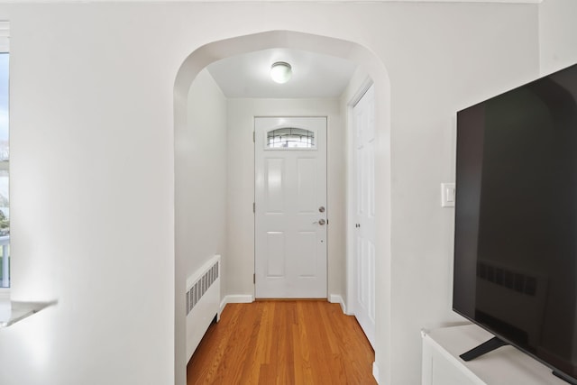 doorway with radiator, light hardwood / wood-style flooring, and plenty of natural light