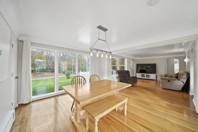 dining room with crown molding, wood-type flooring, and baseboard heating