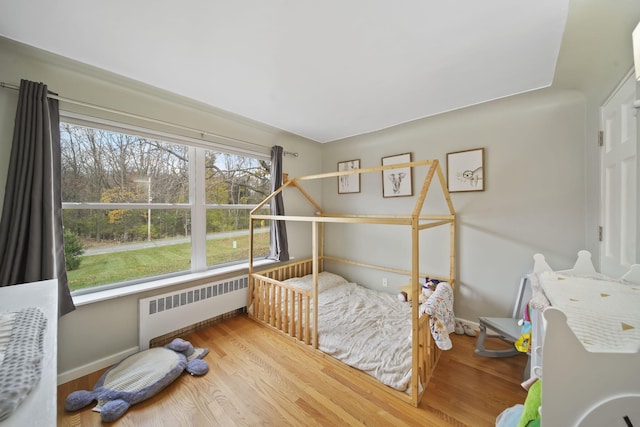 bedroom with wood-type flooring and radiator